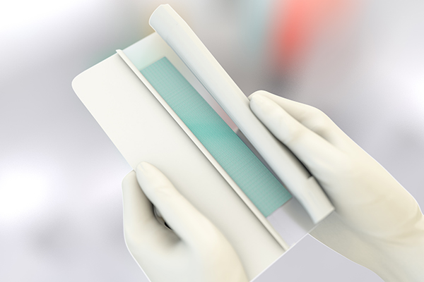 Two hands remove protective film from sorbact surgical dressing